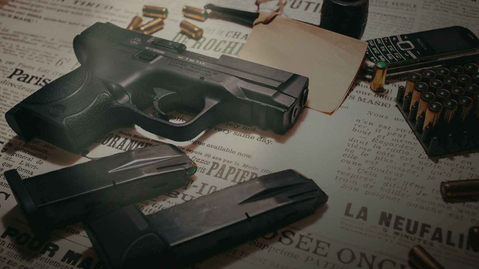 Équipement de tir — pistolet, munitions et couteau sur papier journal